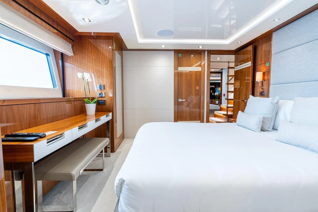 A luxurious stateroom featuring a large bed, wooden furnishings, and ample natural light. aboard ALADDIN Yacht for Sale
