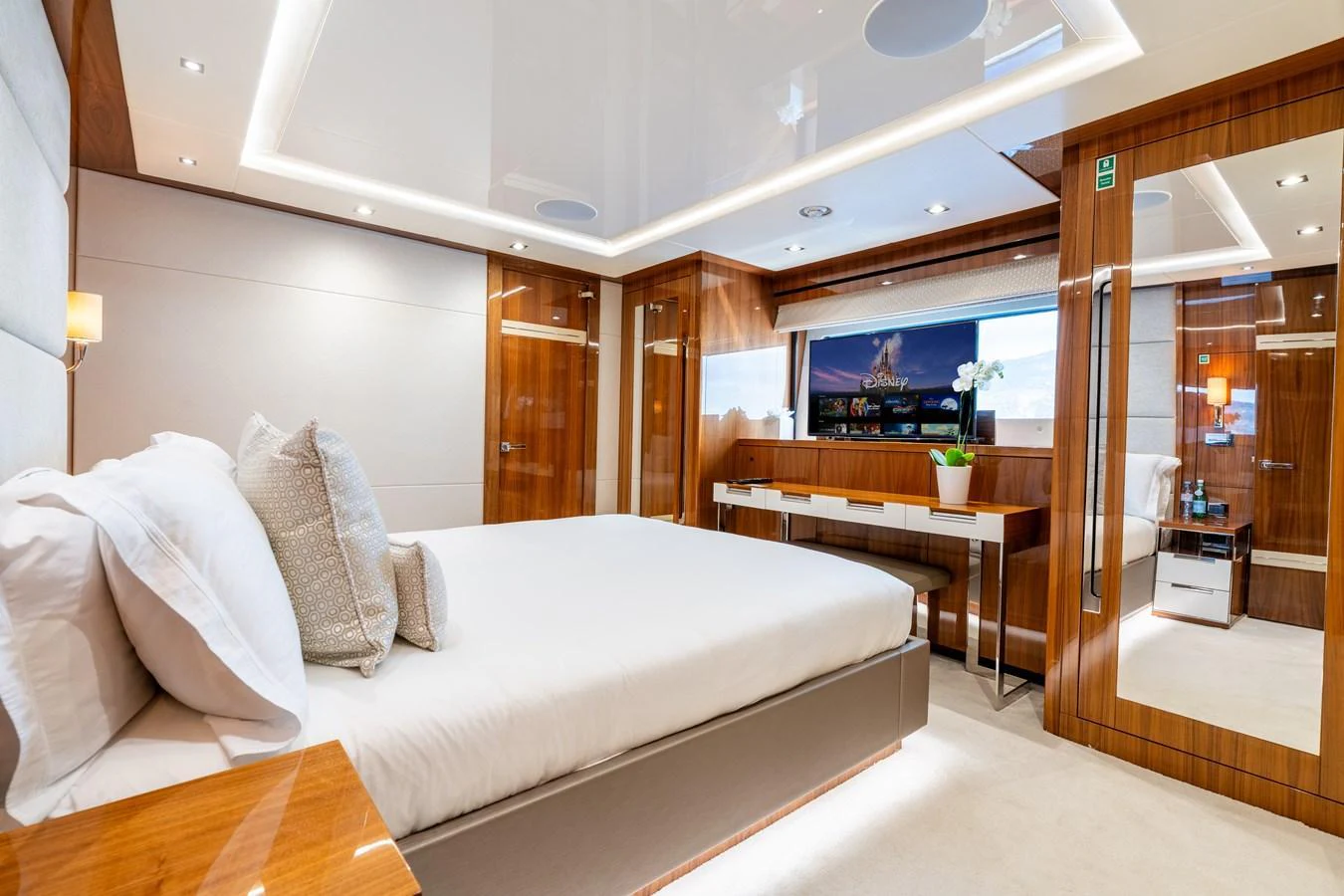 The master stateroom features luxurious bedding and elegant wood finishes, creating a serene and sophisticated atmosphere. aboard ALADDIN Yacht for Sale