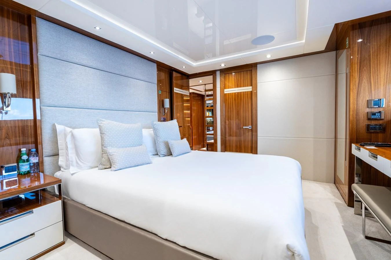 A luxurious stateroom featuring a large bed with plush pillows and elegant wood paneling. aboard ALADDIN Yacht for Sale
