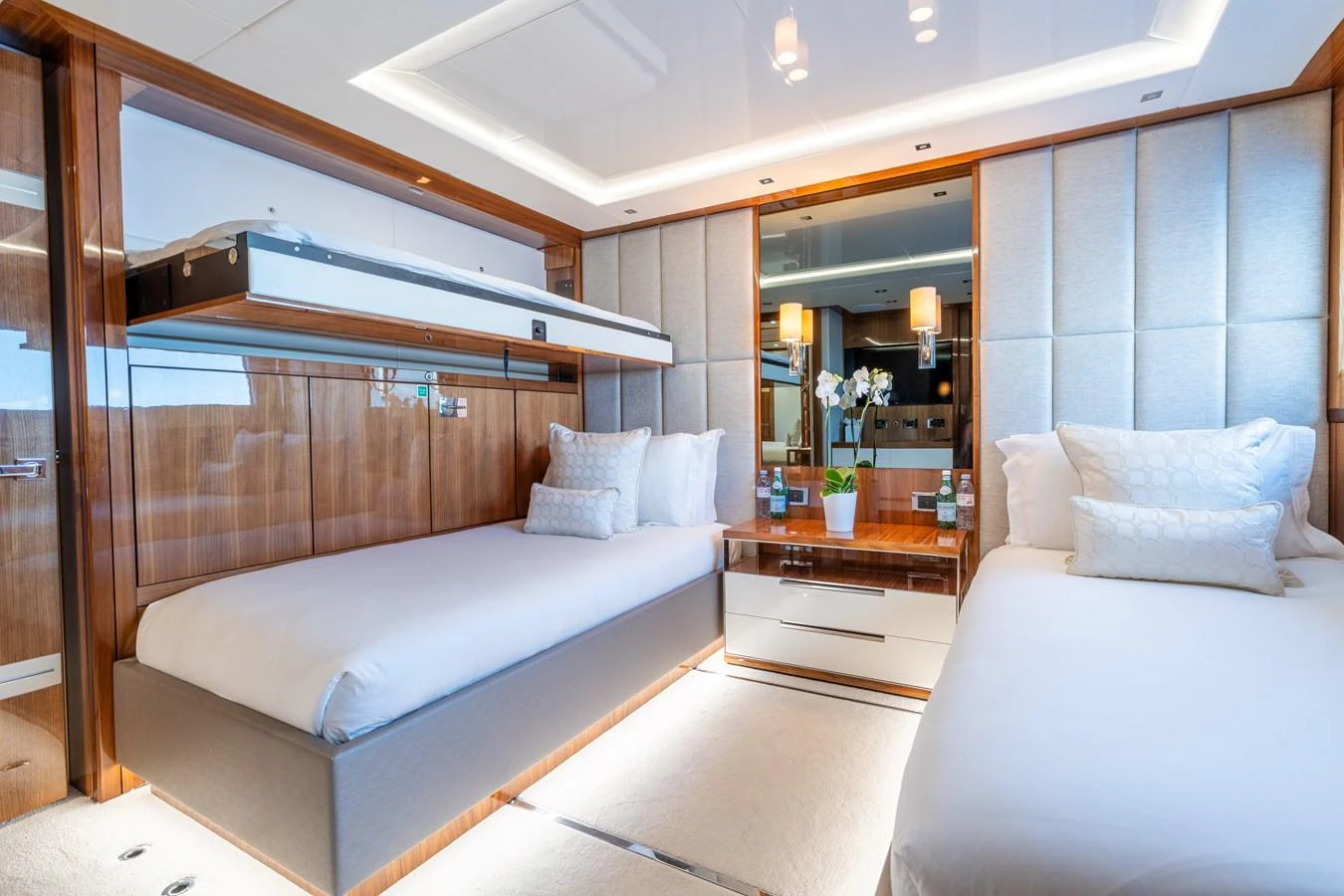 The guest stateroom features twin beds, elegant wood paneling, and soft ambient lighting for a luxurious stay. aboard ALADDIN Yacht for Sale