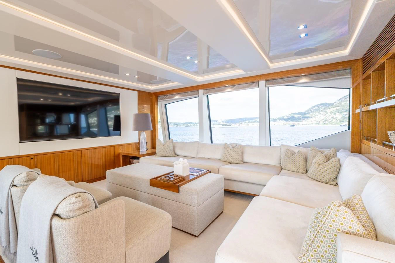 The salon features plush seating, a large flat-screen TV, and expansive windows offering stunning sea views. aboard ALADDIN Yacht for Sale