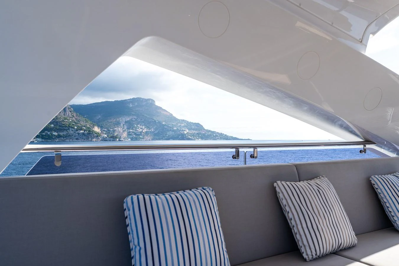 This image showcases a comfortable seating area on the yacht with a scenic view of the coastline. aboard ALADDIN Yacht for Sale