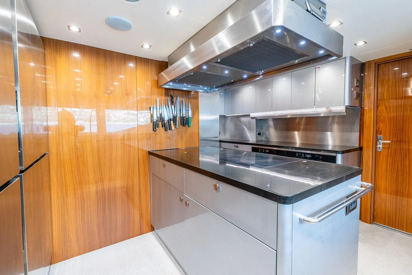 The modern galley features sleek stainless steel appliances and warm wood paneling. aboard ALADDIN Yacht for Sale