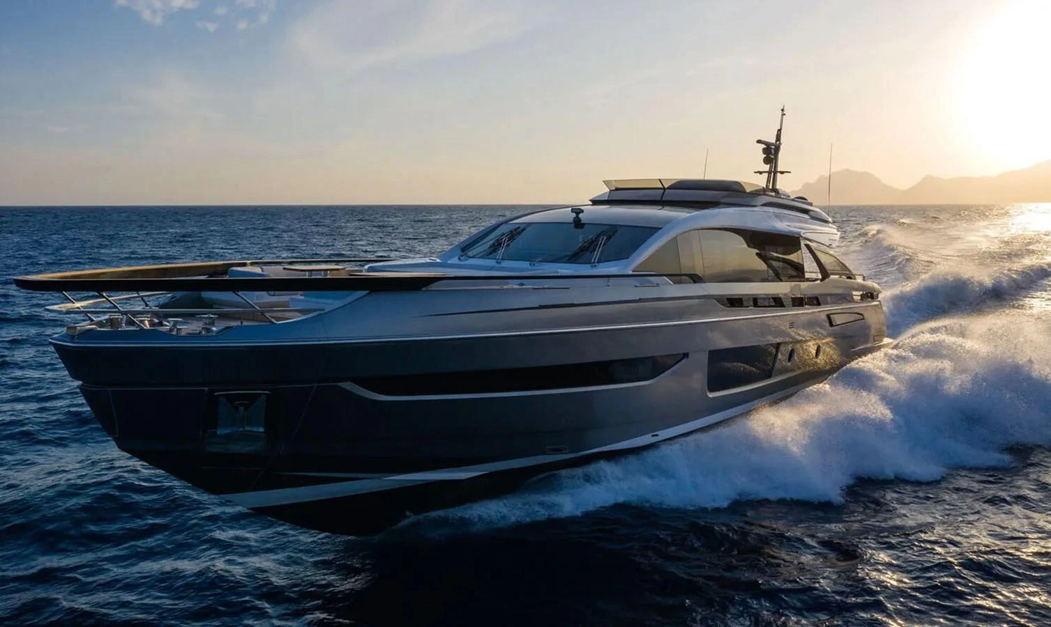 A sleek and modern yacht cruises swiftly on the open sea at sunset. aboard LANCE WEST Yacht for Sale