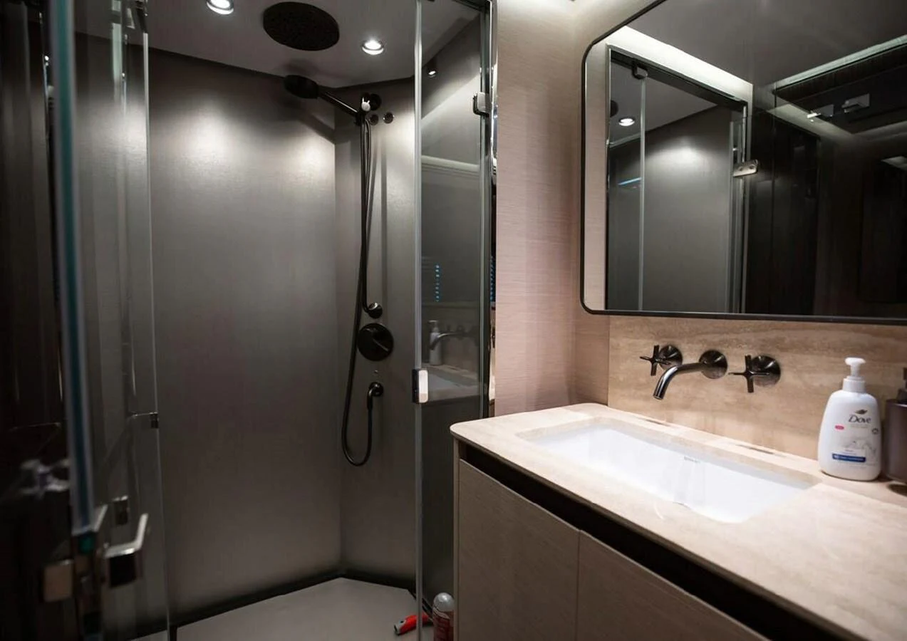 The yacht's bathroom features a modern shower and a sleek vanity with a large mirror. aboard LANCE WEST Yacht for Sale