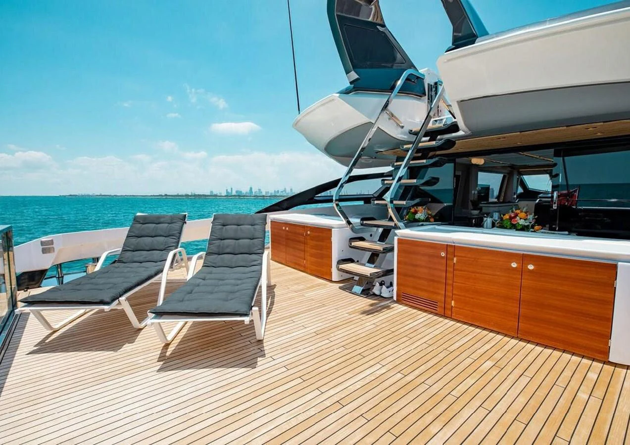 The aft deck features a spacious lounging area with sunbeds and a sleek staircase leading to the upper deck. aboard LANCE WEST Yacht for Sale