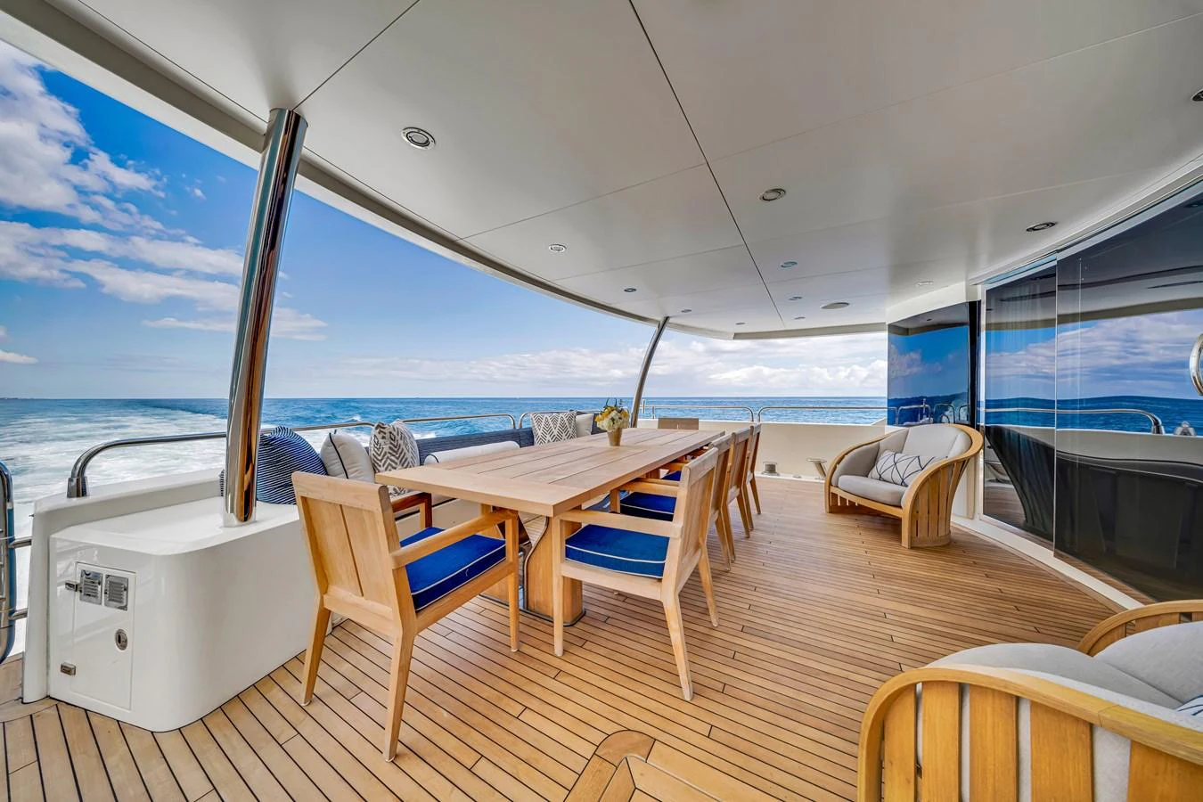 The aft deck features an elegant dining area with stunning ocean views. aboard NATURAL 9 Yacht for Sale