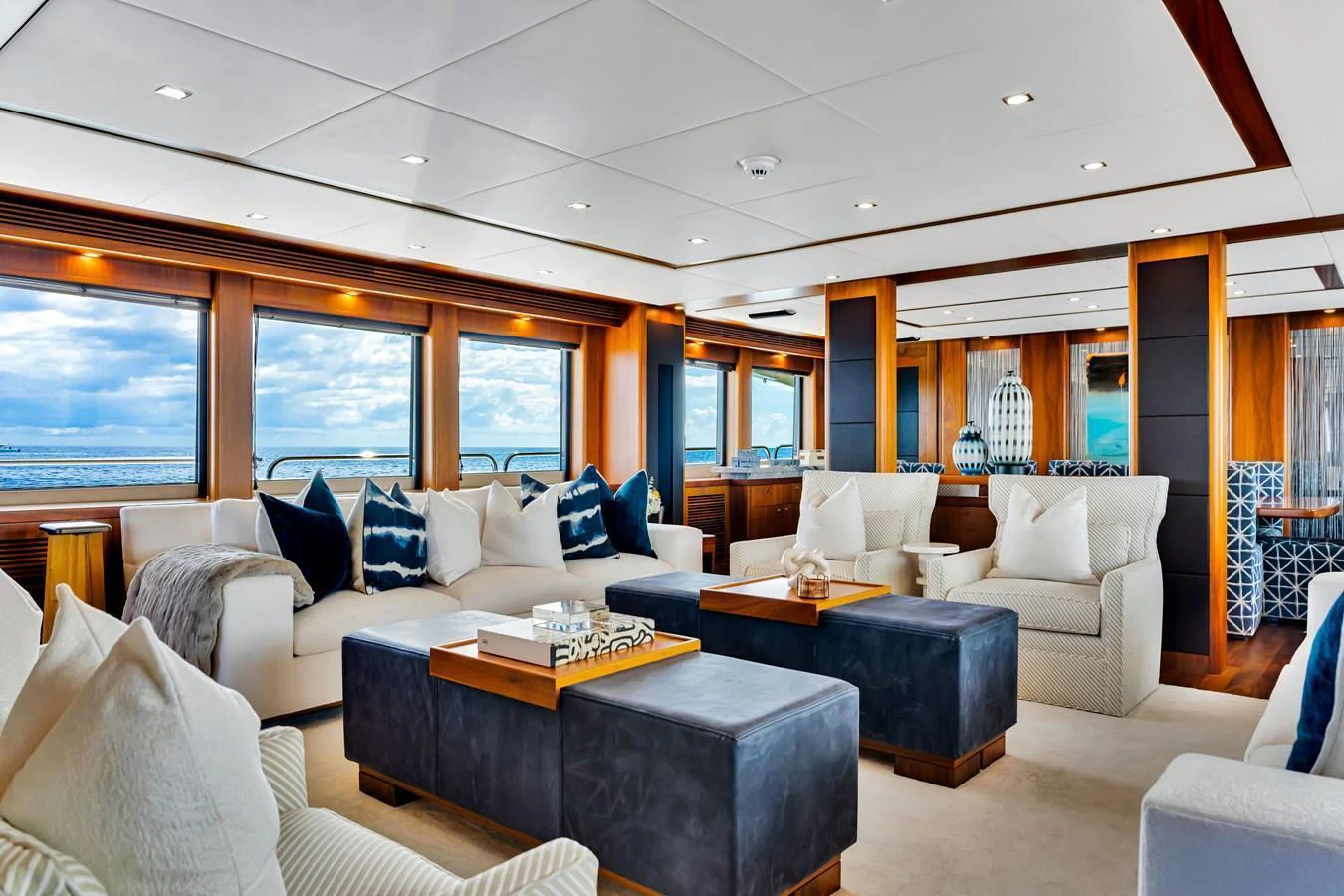 The yacht's salon exudes luxury with plush seating, elegant decor, and expansive windows offering stunning ocean views. aboard NATURAL 9 Yacht for Sale