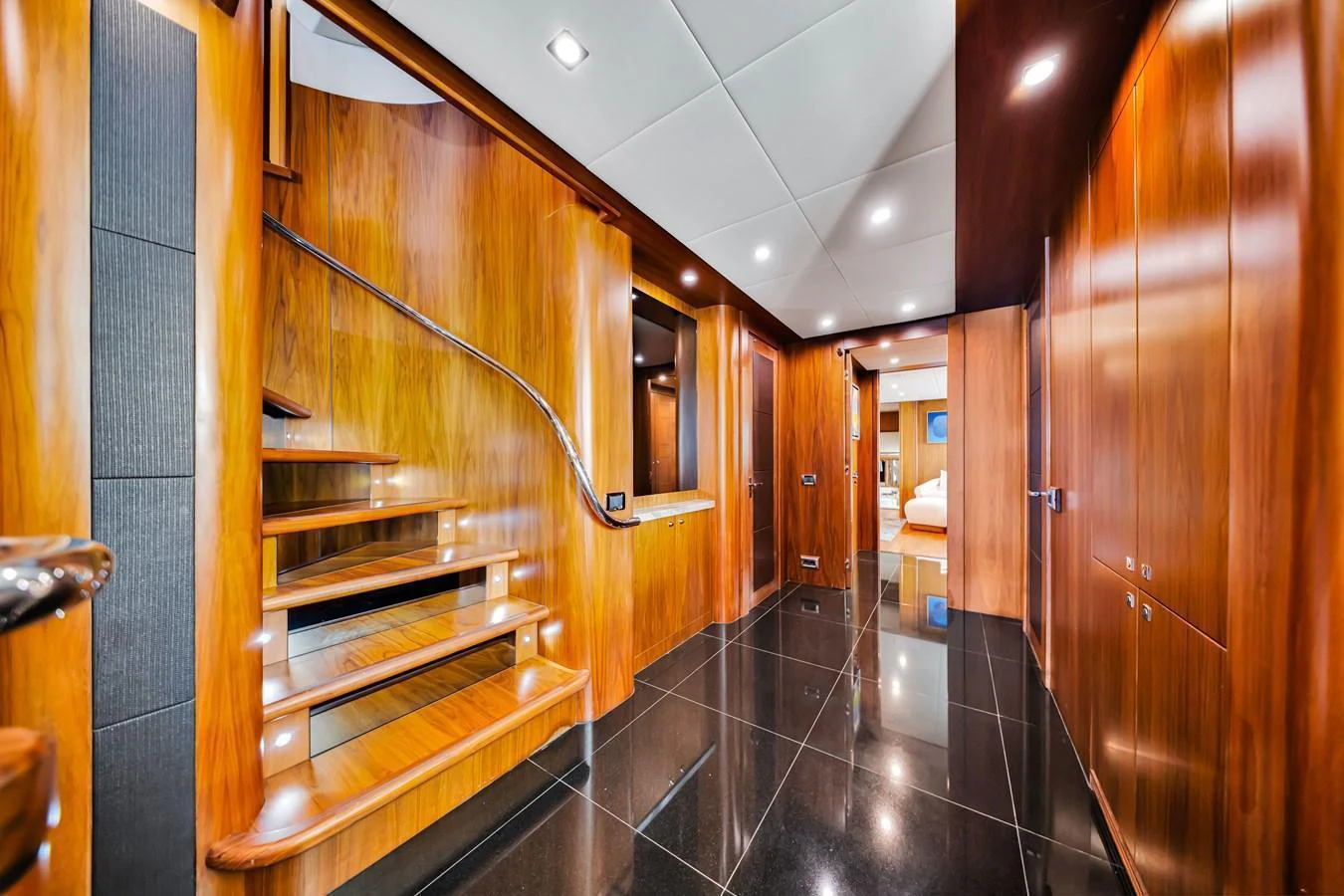 The yacht's interior features a sleek hallway with polished wood finishes and modern lighting. aboard NATURAL 9 Yacht for Sale