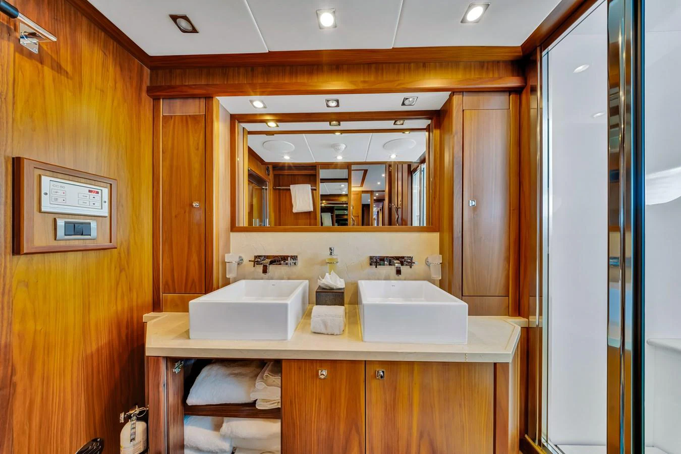 The yacht's bathroom features a luxurious double sink vanity with ample storage and elegant wood finishes. aboard NATURAL 9 Yacht for Sale