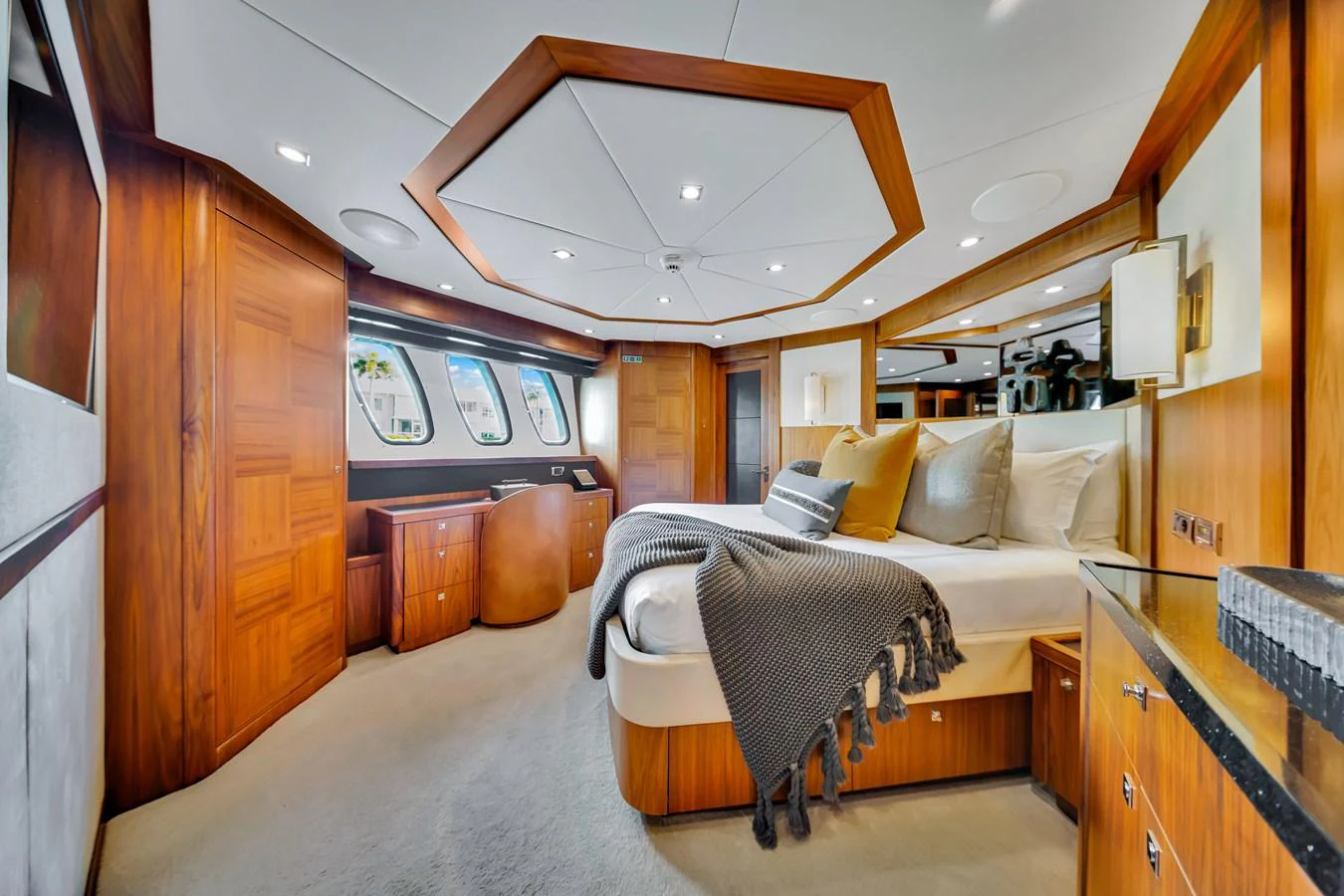 The master stateroom features luxurious wood paneling, a large bed, and ample natural light from the windows. aboard NATURAL 9 Yacht for Sale
