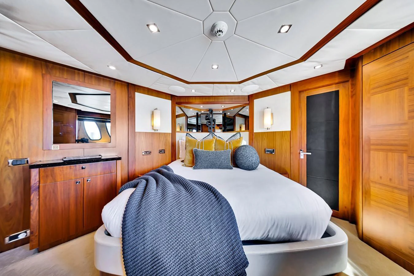 The master stateroom features luxurious wood paneling and a plush bed with elegant bedding. aboard NATURAL 9 Yacht for Sale