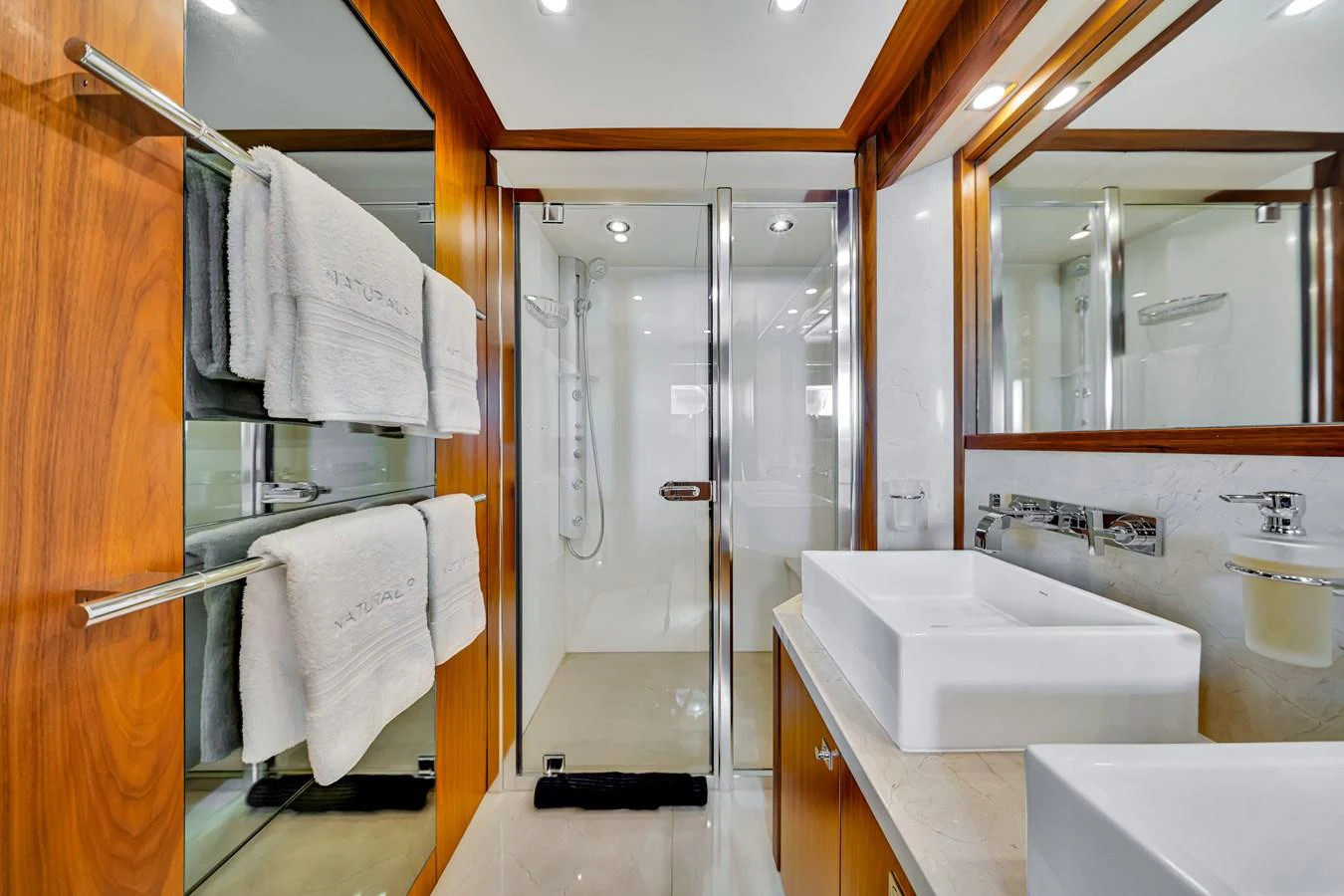 The yacht's bathroom features a modern design with dual sinks and a spacious shower area. aboard NATURAL 9 Yacht for Sale