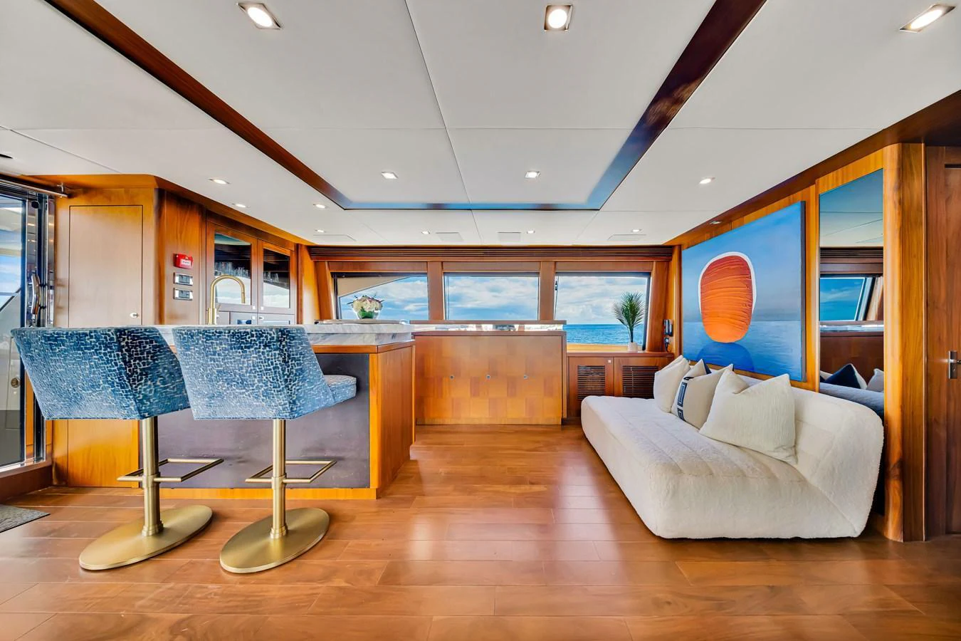 The salon features a modern design with plush seating and panoramic windows offering stunning ocean views. aboard NATURAL 9 Yacht for Sale