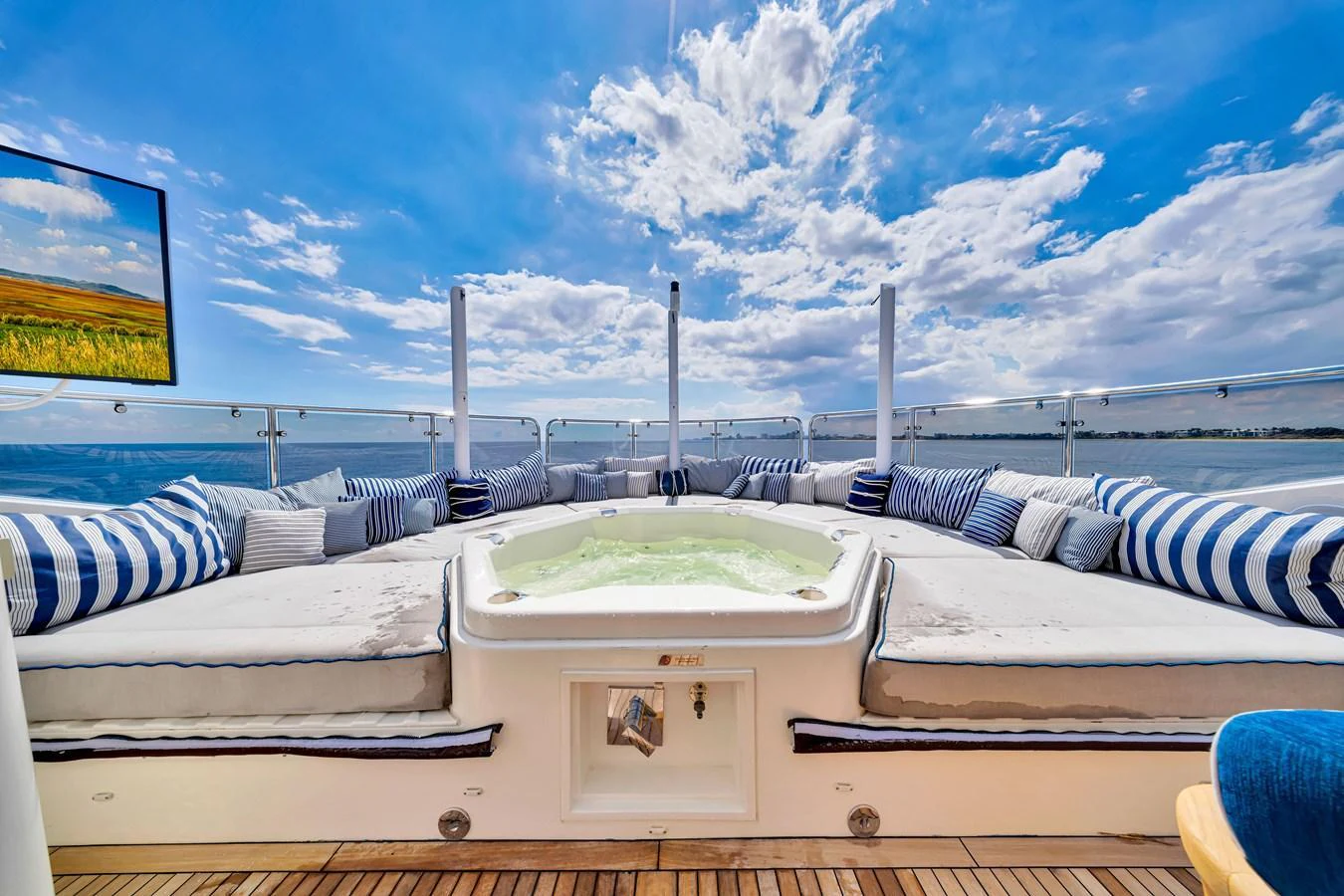 The sundeck features a luxurious jacuzzi surrounded by plush seating, perfect for relaxation under the open sky. aboard NATURAL 9 Yacht for Sale