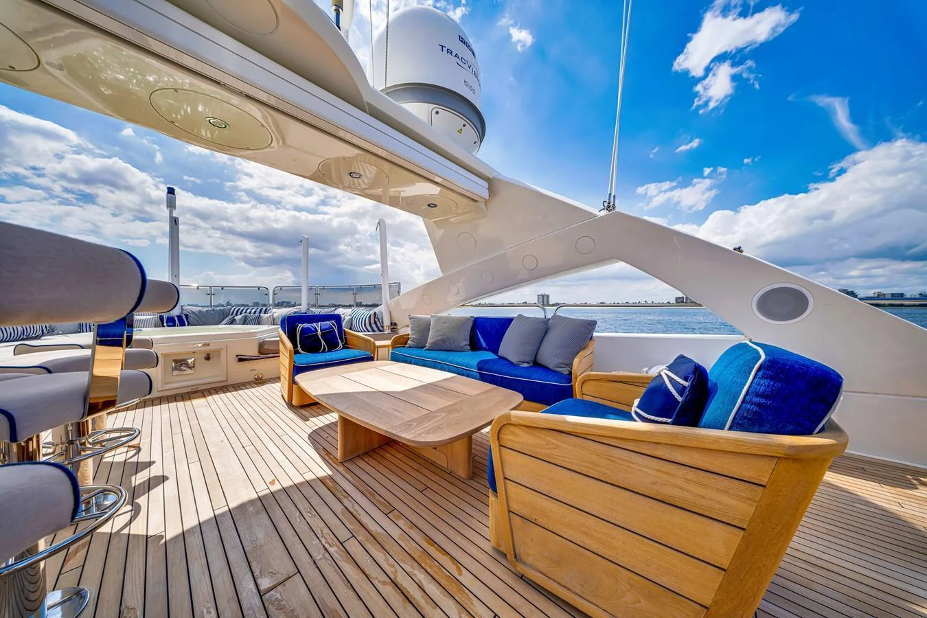 The flybridge offers a spacious and stylish outdoor seating area with comfortable wooden furniture and a stunning view of the water. aboard NATURAL 9 Yacht for Sale