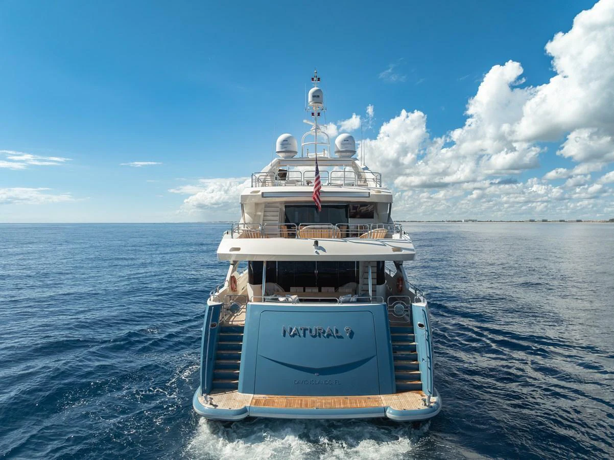 A luxurious yacht cruising on the open sea with a clear blue sky backdrop. aboard NATURAL 9 Yacht for Sale