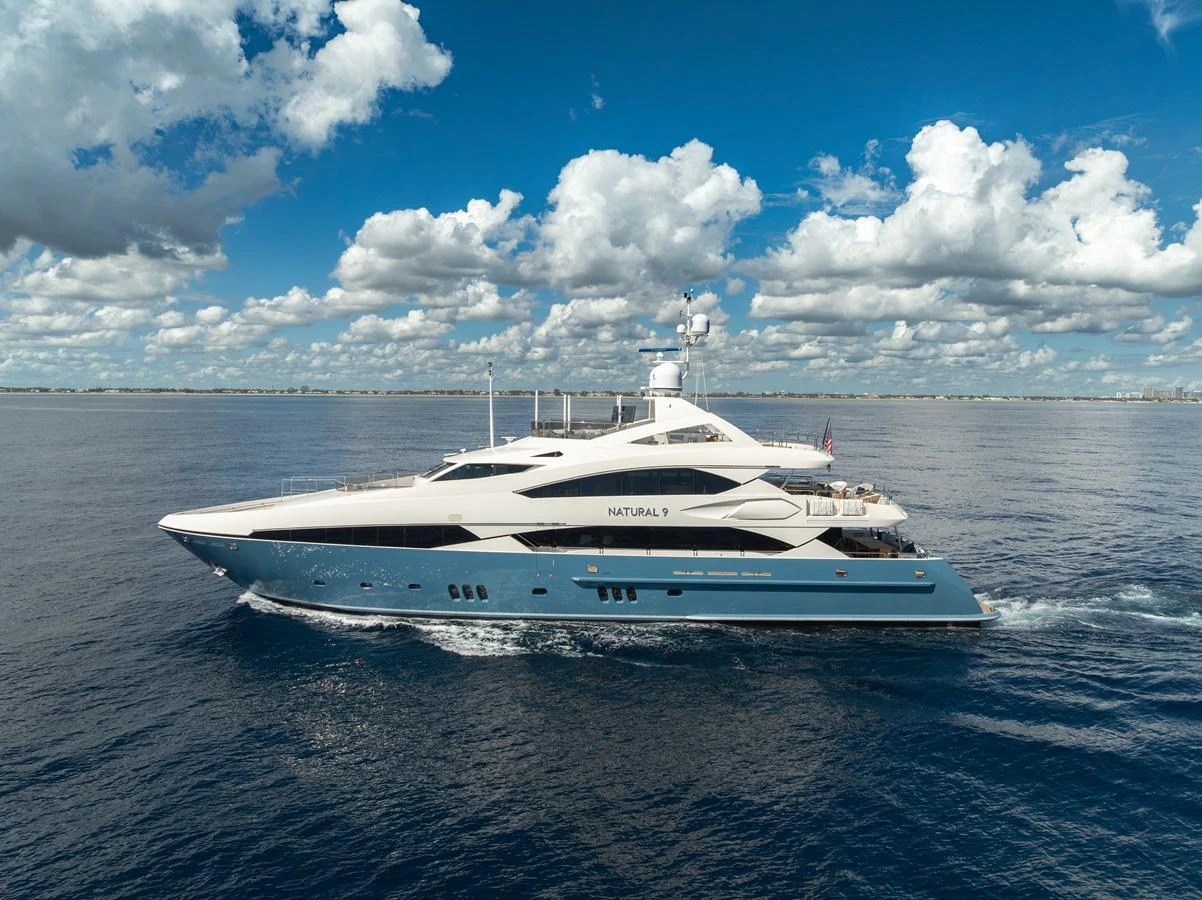 A sleek and elegant yacht cruising on calm waters under a vibrant blue sky. aboard NATURAL 9 Yacht for Sale