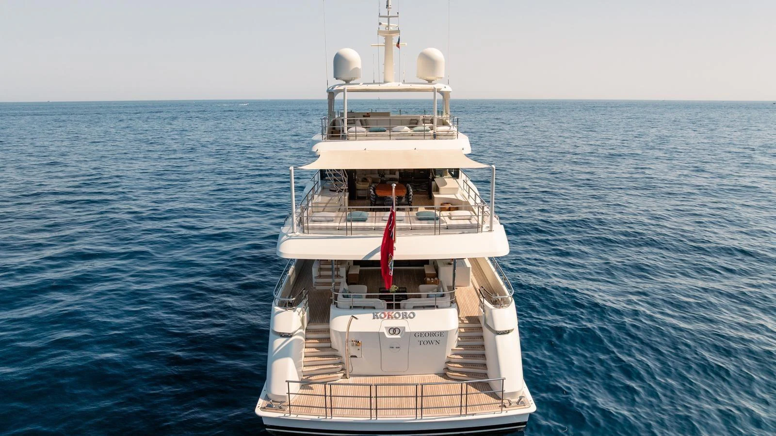 A luxurious yacht is anchored on calm waters, showcasing its multiple decks and elegant design. aboard KOKORO Yacht for Sale