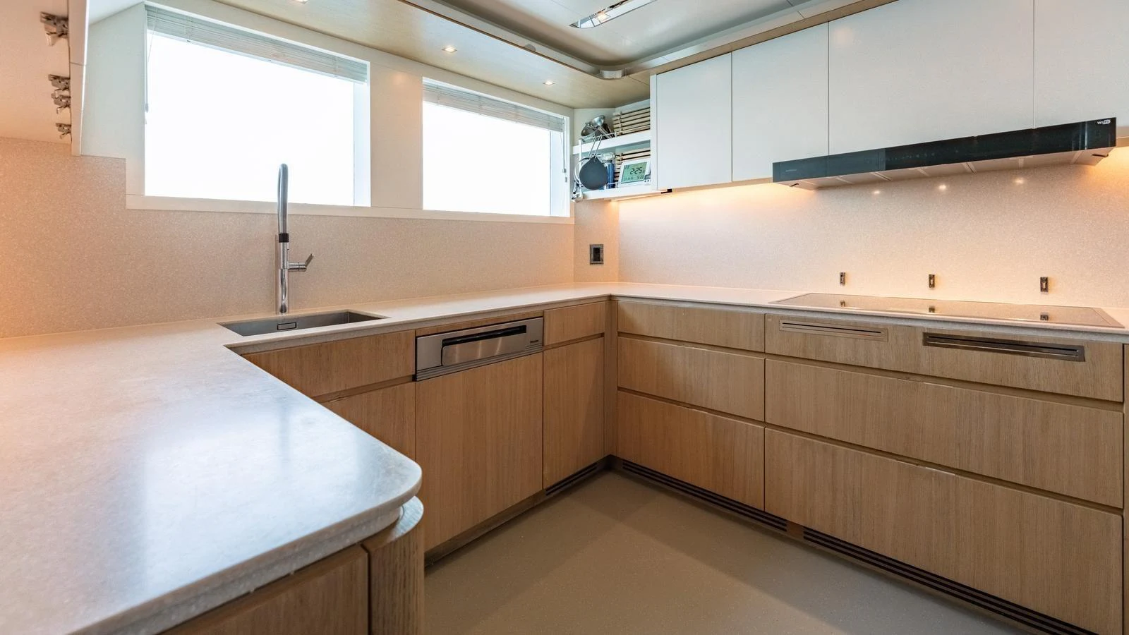 The galley features modern cabinetry, ample counter space, and large windows for natural light. aboard KOKORO Yacht for Sale