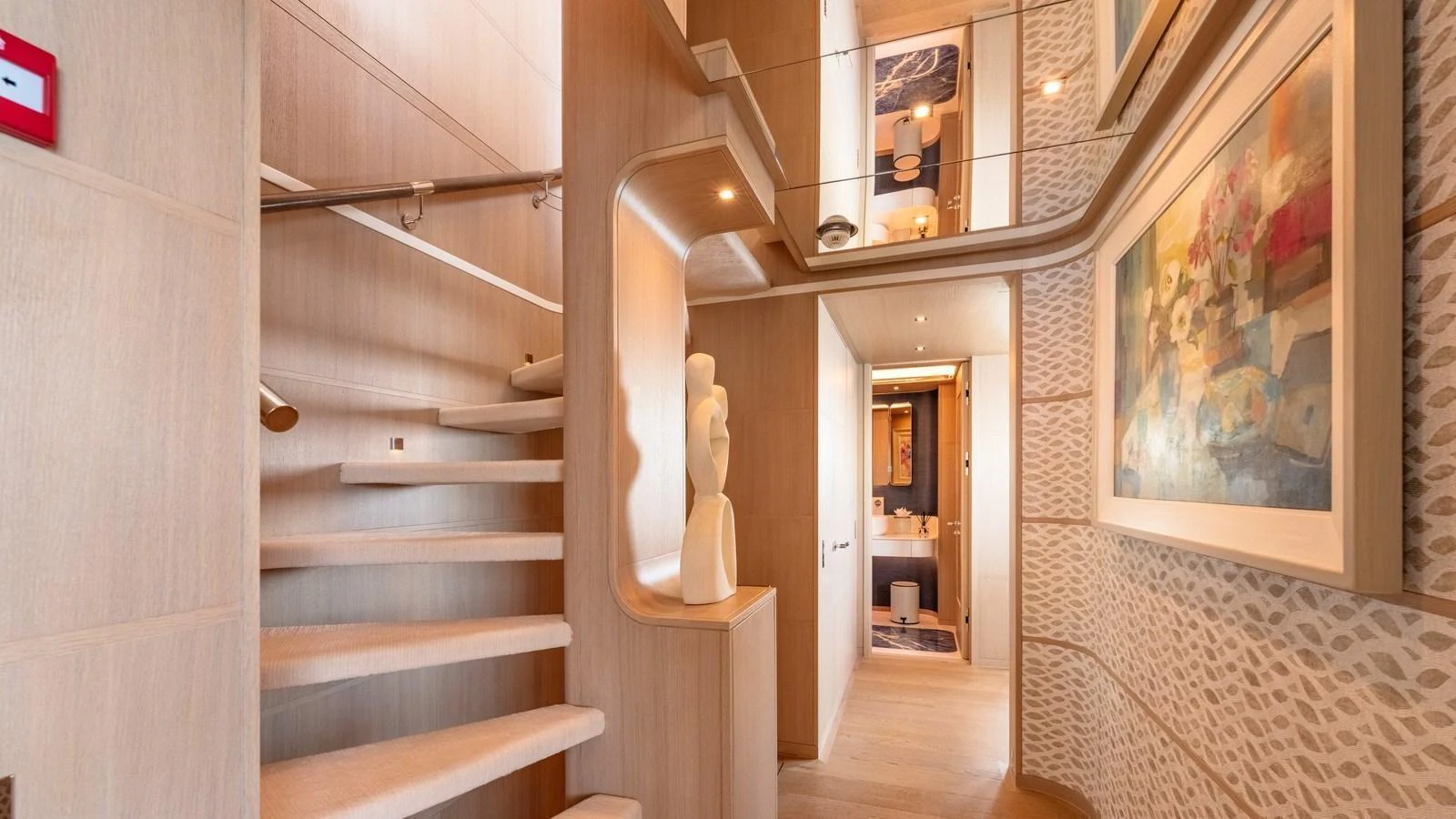 The yacht's interior features a beautifully designed staircase with elegant artwork and modern decor. aboard KOKORO Yacht for Sale
