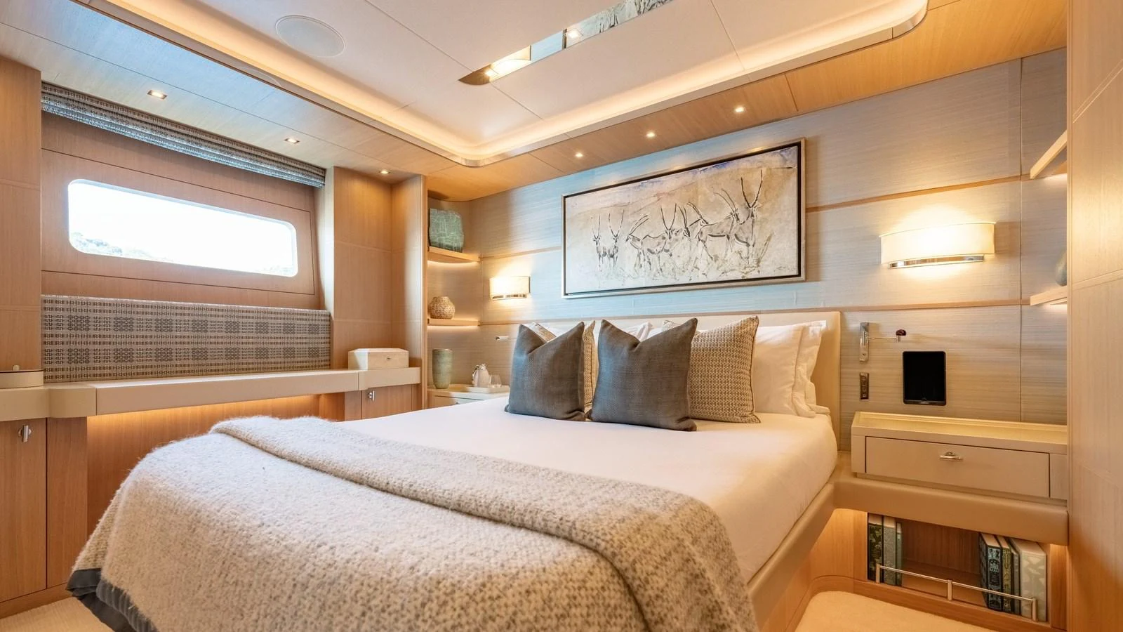 The stateroom features a luxurious bed with elegant decor and ample natural light. aboard KOKORO Yacht for Sale