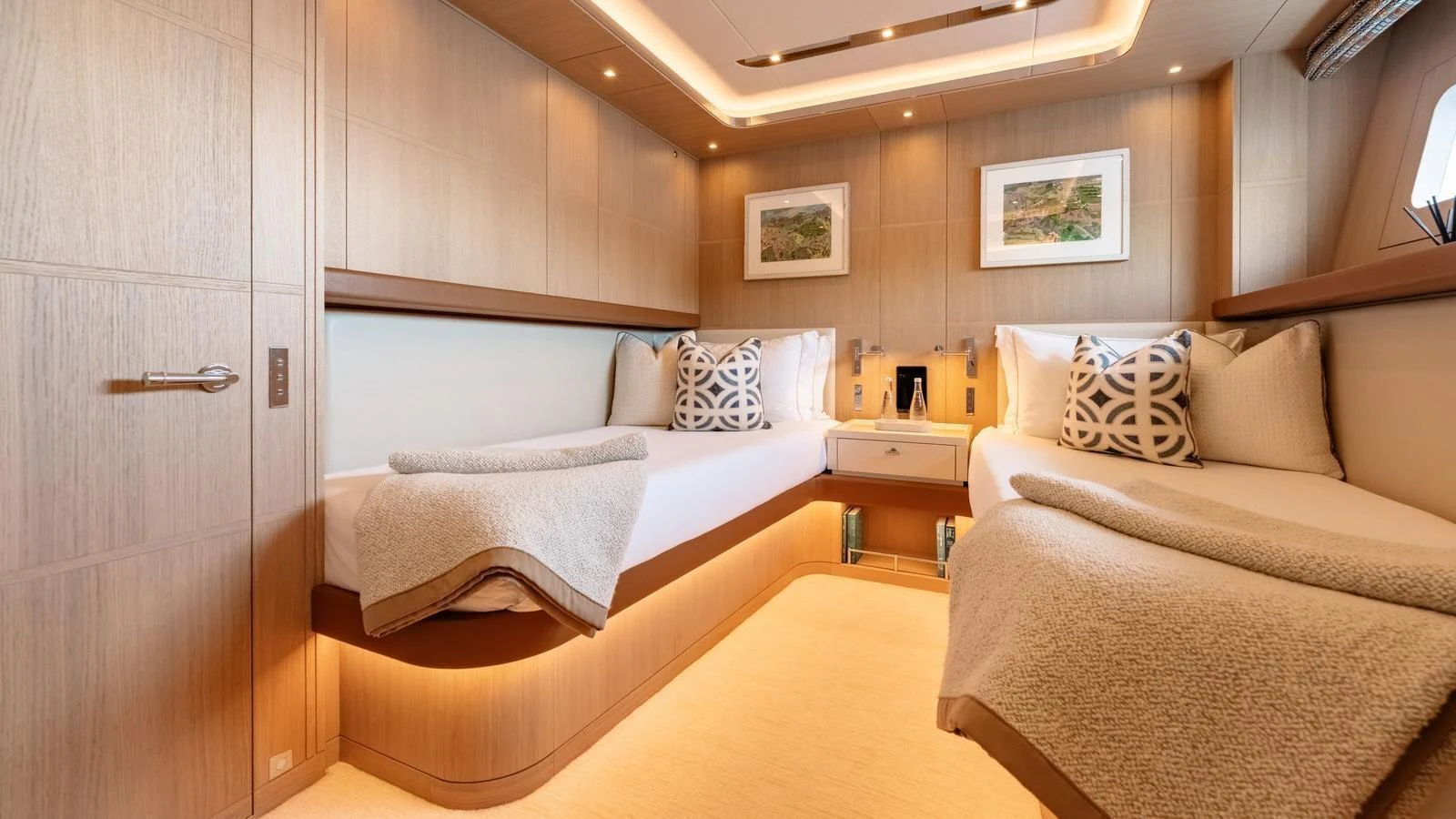 The guest stateroom features twin beds with elegant bedding and warm ambient lighting. aboard KOKORO Yacht for Sale