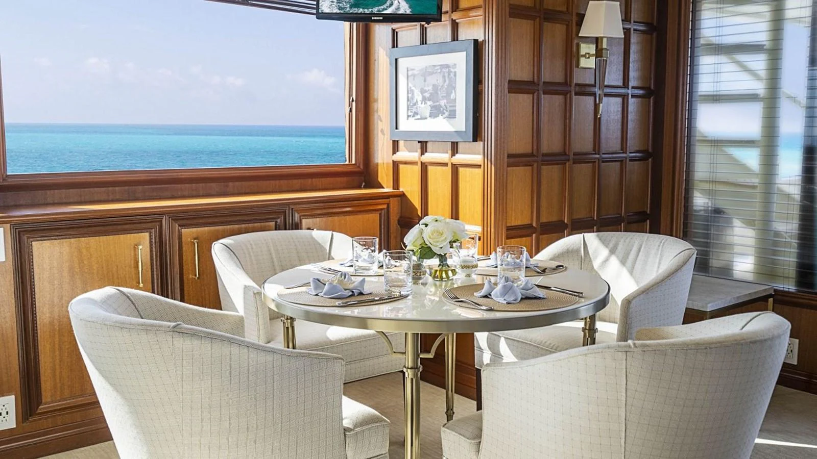 A luxurious dining area with a stunning ocean view through the window. aboard TRUE NORTH Yacht for Sale