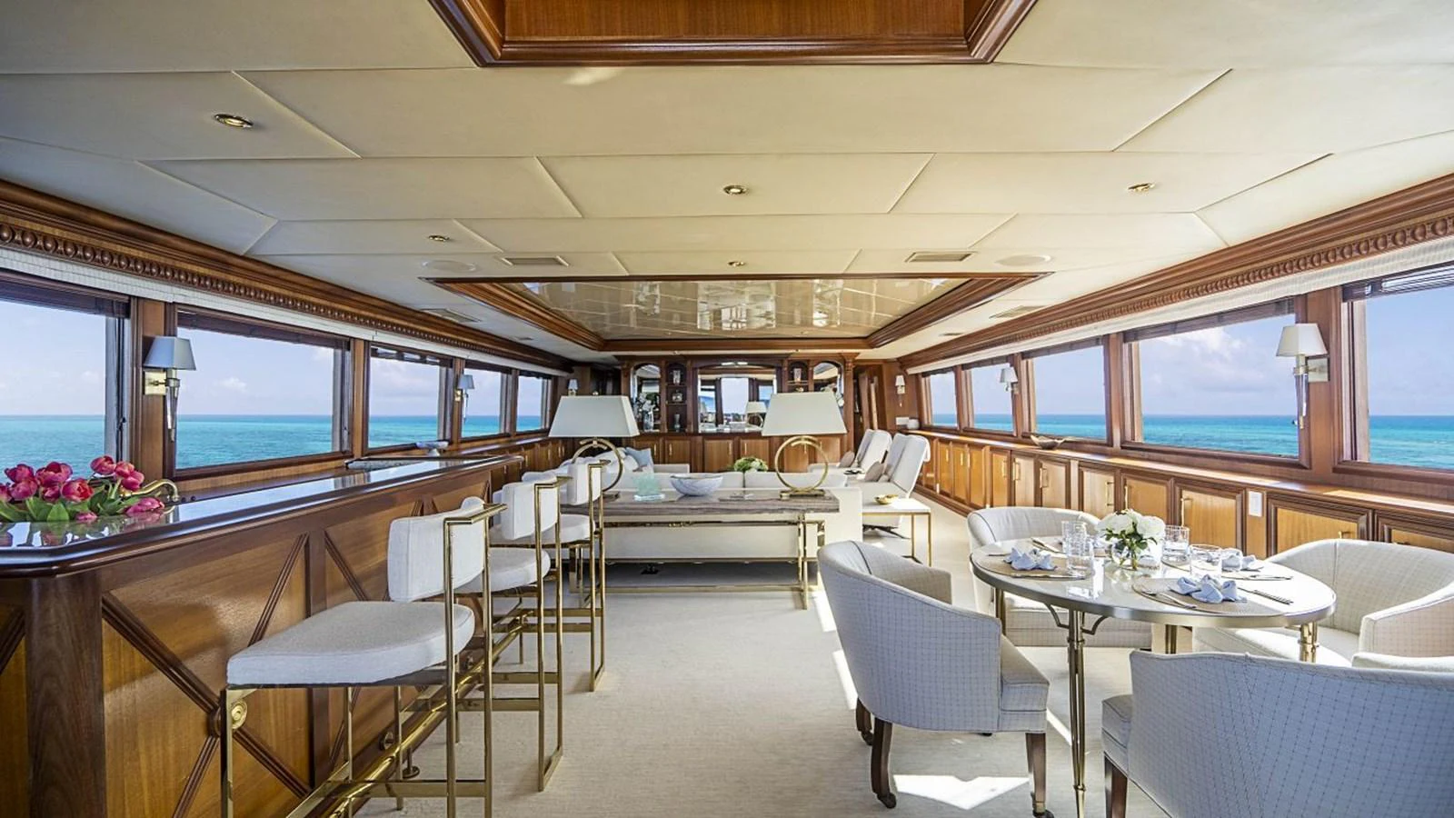 The yacht's salon offers a spacious and elegant setting with panoramic ocean views. aboard TRUE NORTH Yacht for Sale