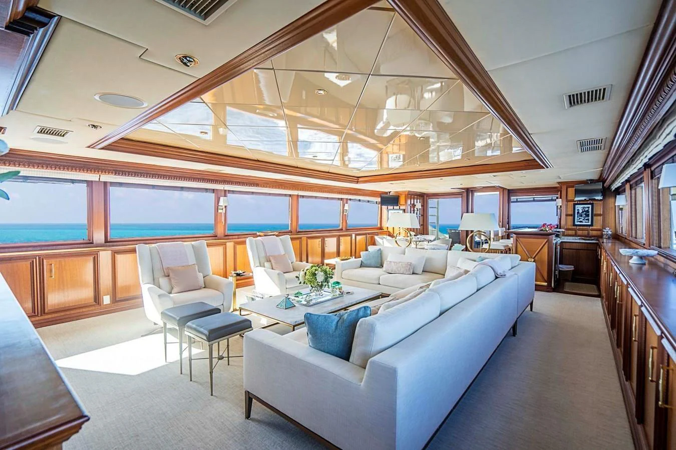 The yacht's salon features luxurious seating with panoramic ocean views and elegant wood finishes. aboard TRUE NORTH Yacht for Sale