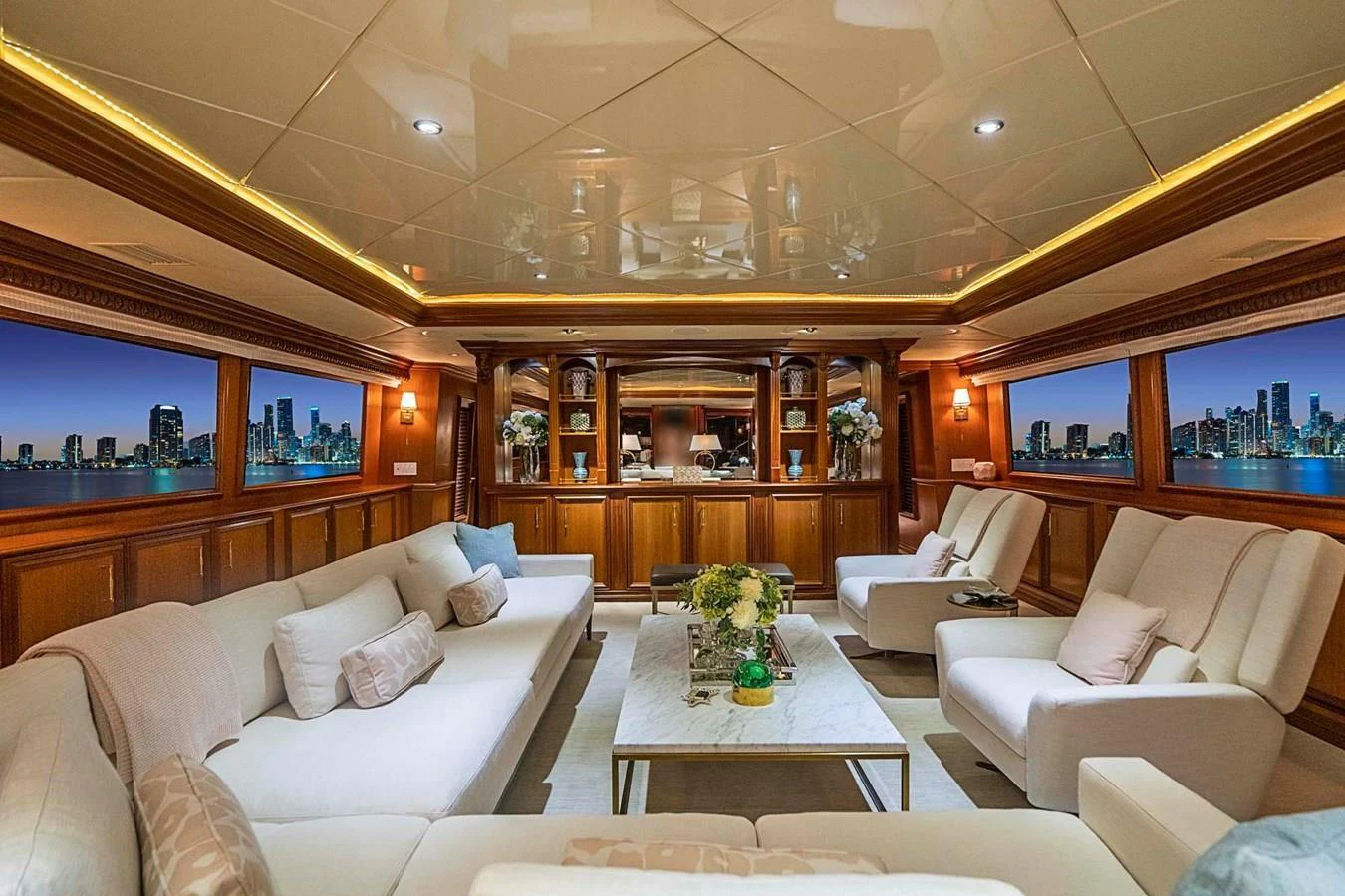 The salon features luxurious seating with panoramic views of the city skyline. aboard TRUE NORTH Yacht for Sale