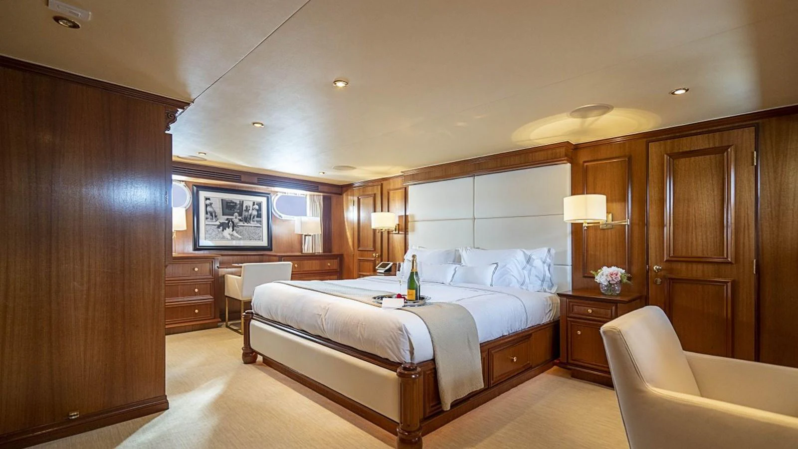 The master stateroom features a luxurious bed with elegant wood paneling and soft lighting. aboard TRUE NORTH Yacht for Sale