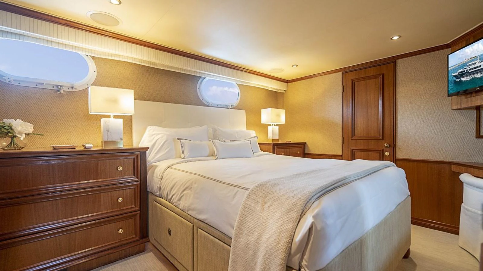 The stateroom features a plush bed with elegant wooden furnishings and soft lighting. aboard TRUE NORTH Yacht for Sale