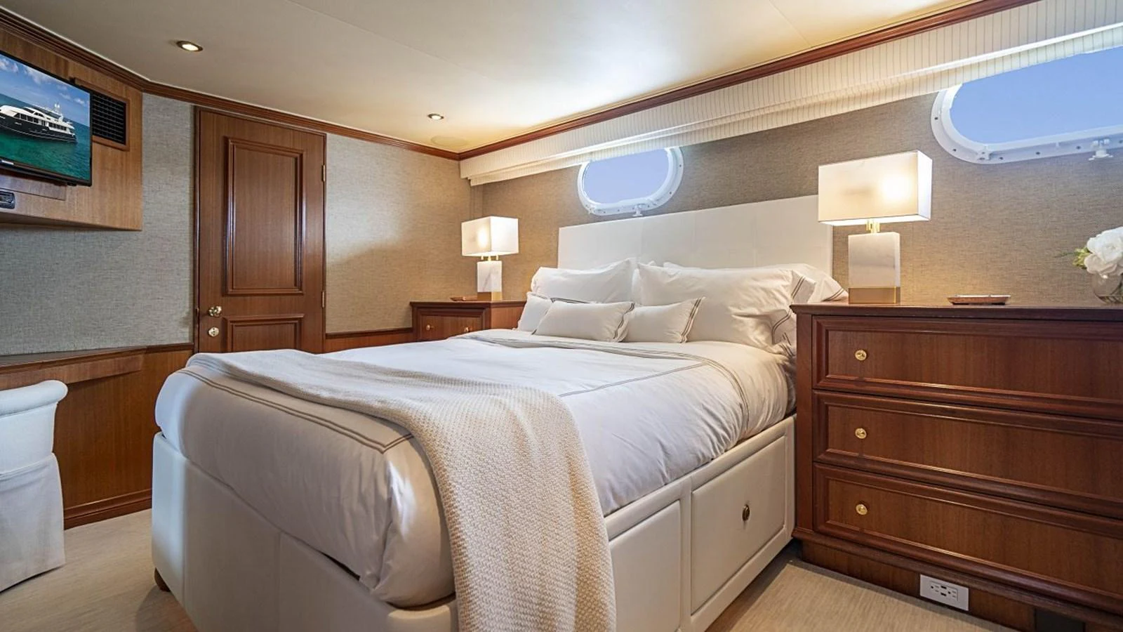 The stateroom features a plush bed with elegant wooden furnishings and soft ambient lighting. aboard TRUE NORTH Yacht for Sale
