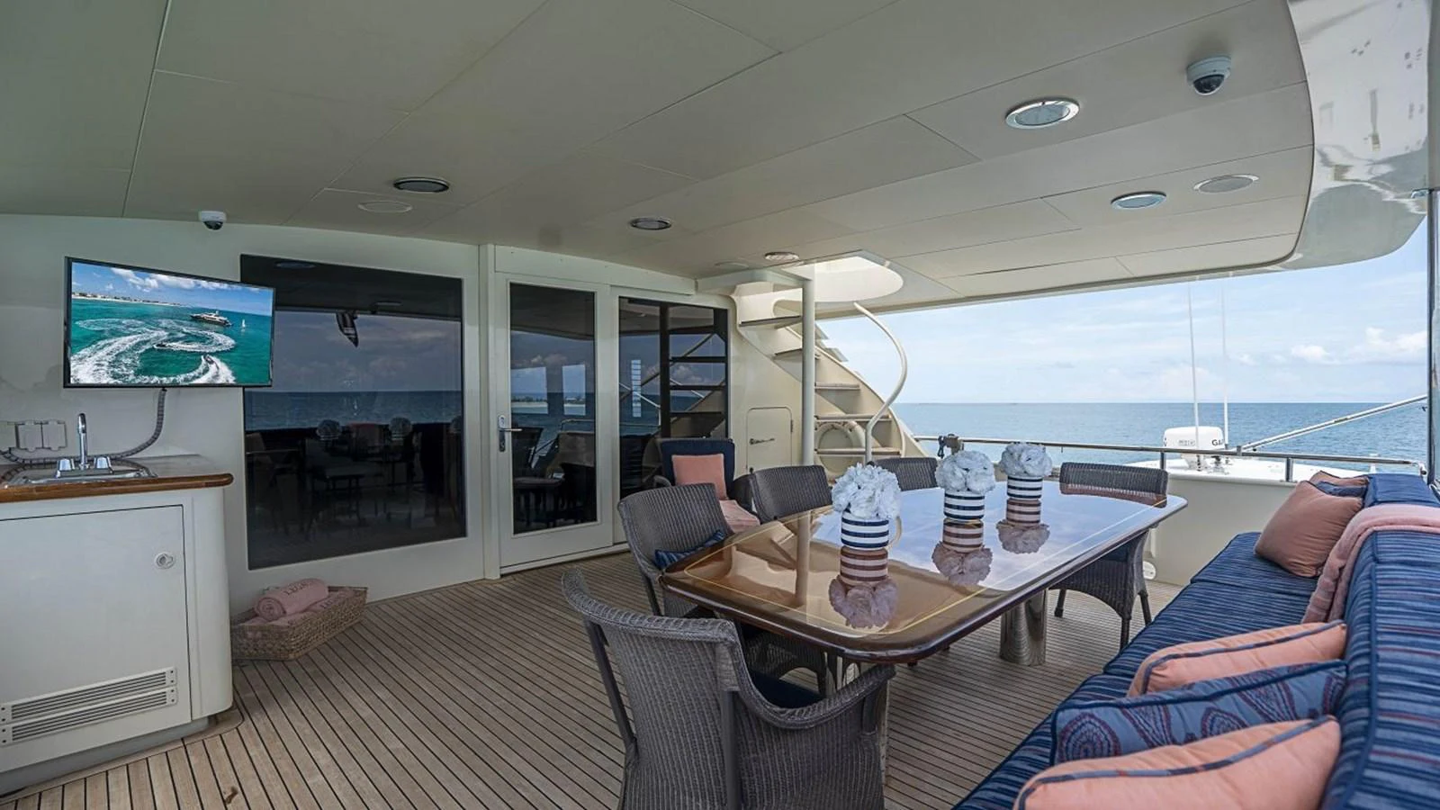 The aft deck features a spacious dining area with a large table and comfortable seating, perfect for enjoying meals with a view of the sea. aboard TRUE NORTH Yacht for Sale