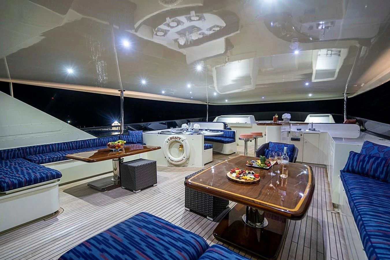 The aft deck offers a spacious and inviting area for dining and relaxation under a sleek, reflective ceiling. aboard TRUE NORTH Yacht for Sale
