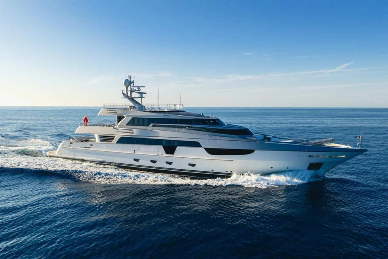 A sleek and modern yacht glides through the open sea under a clear blue sky. aboard ANTALIS Yacht for Sale