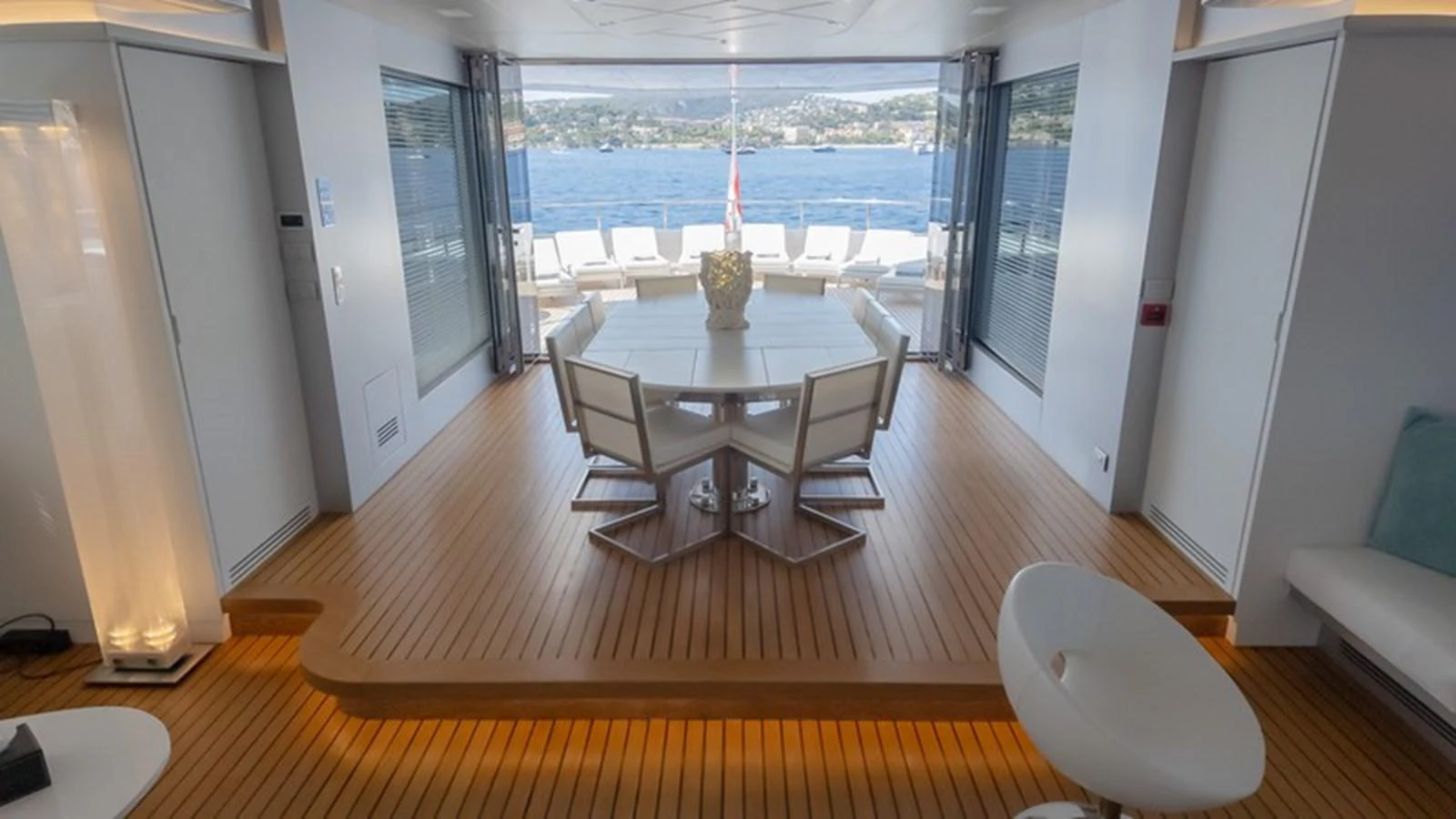 A stylish dining area with a view of the sea, featuring a modern table and chairs on a wooden floor. aboard ANTALIS Yacht for Sale