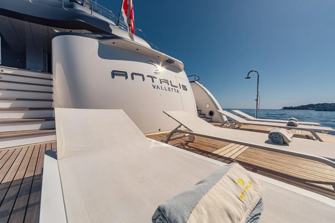 The aft deck of the yacht features luxurious sun loungers and a view of the serene sea. aboard ANTALIS Yacht for Sale