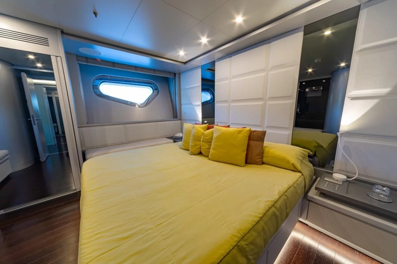 A luxurious stateroom featuring a large bed with yellow bedding and modern lighting. aboard ANTALIS Yacht for Sale