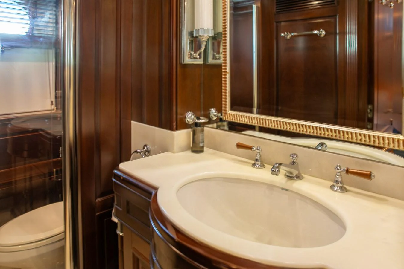The yacht's bathroom features elegant wood paneling and a polished sink area. aboard ANYPA Yacht for Sale