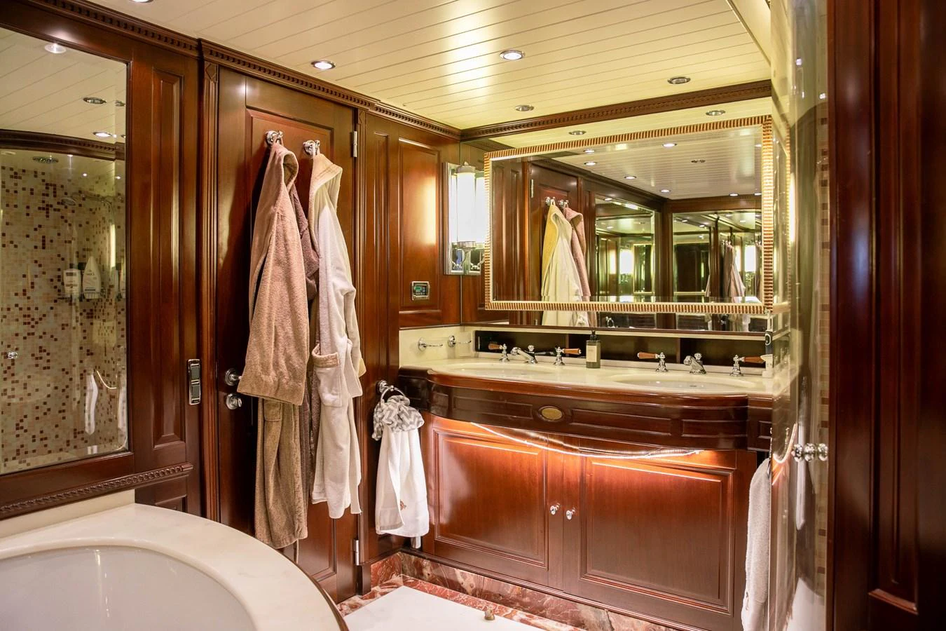 The yacht's bathroom features luxurious wood paneling, a spacious vanity, and elegant fixtures. aboard ANYPA Yacht for Sale