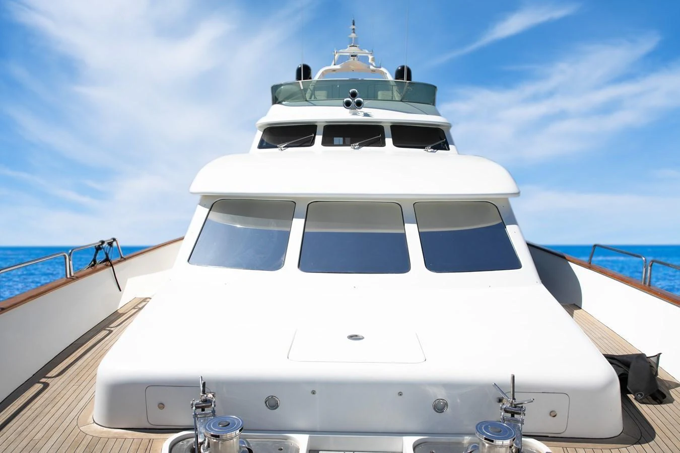 The yacht's bow is showcased against a clear blue sky and calm sea. aboard ANYPA Yacht for Sale