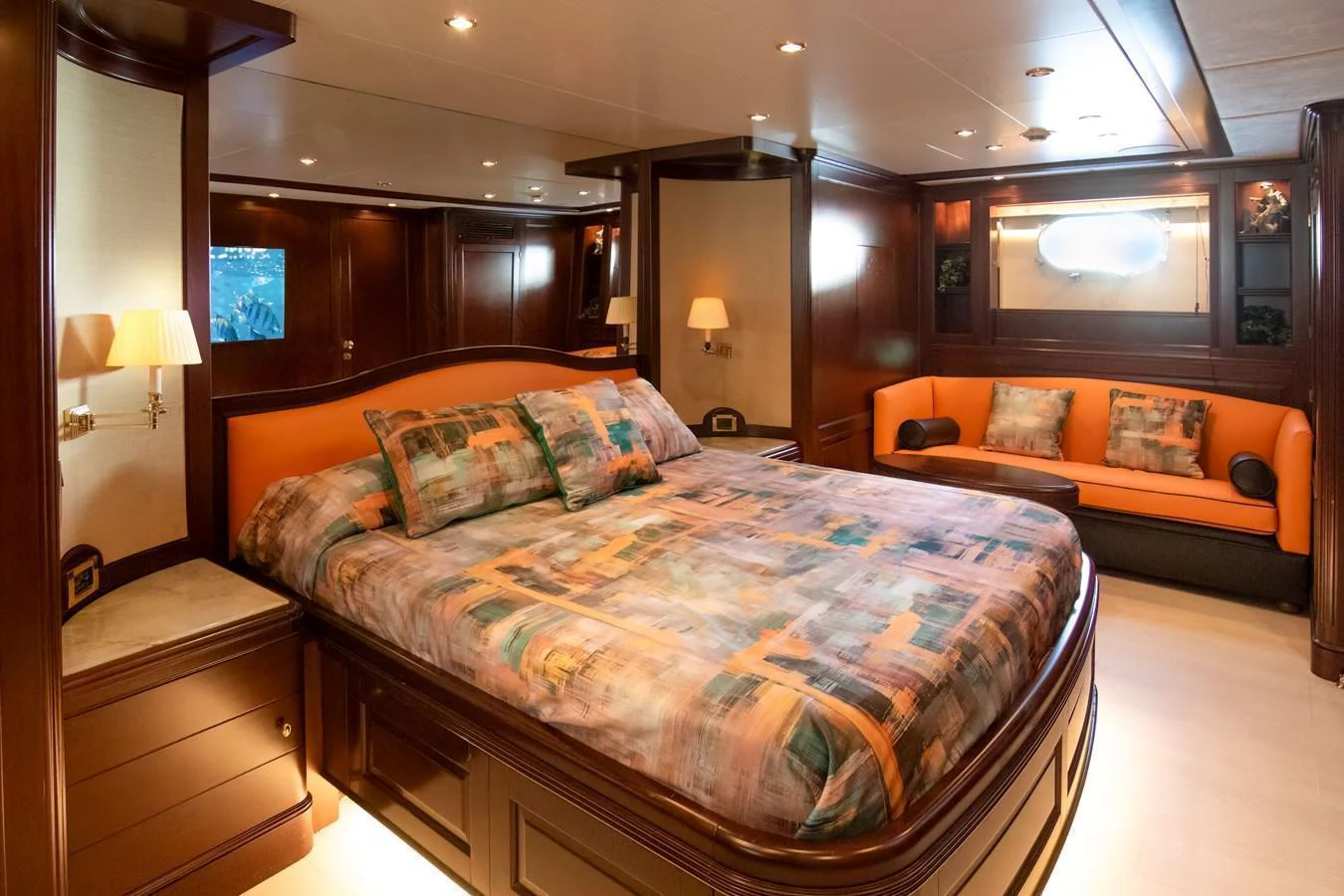 The master stateroom features a luxurious bed with vibrant bedding and a cozy seating area. aboard ANYPA Yacht for Sale