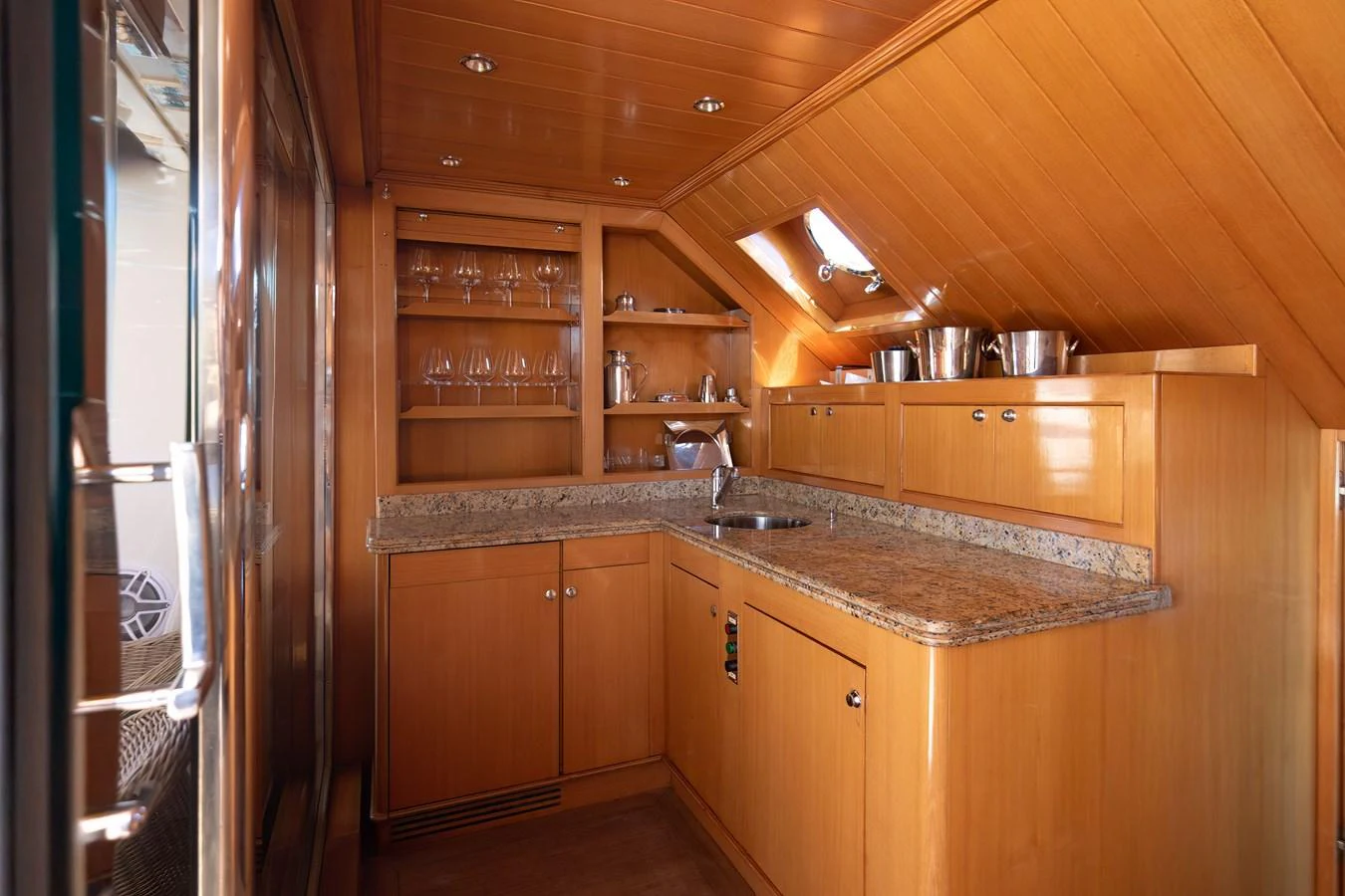 The yacht's galley features warm wood cabinetry and granite countertops, creating a cozy and functional space. aboard ANYPA Yacht for Sale