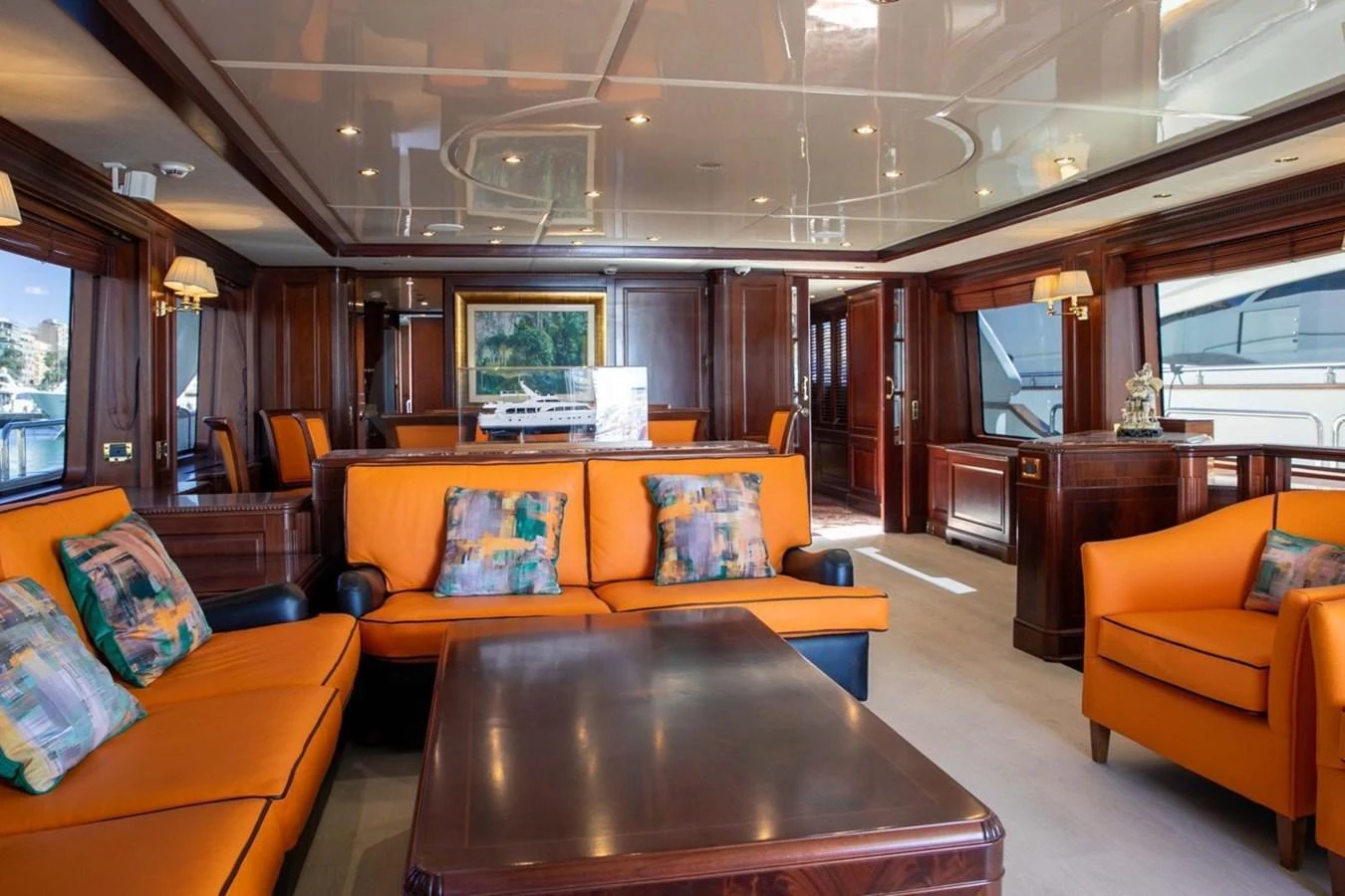 The salon features vibrant orange seating and elegant wooden finishes, creating a warm and inviting atmosphere. aboard ANYPA Yacht for Sale