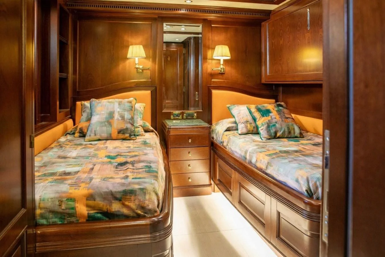 The twin stateroom features warm wood paneling and cozy twin beds with colorful bedding. aboard ANYPA Yacht for Sale