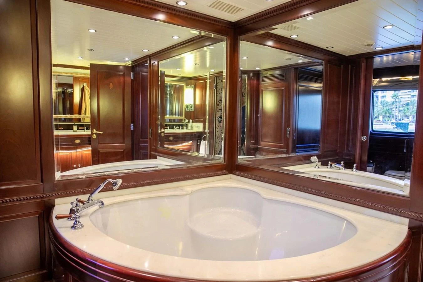 The luxurious bathroom features a large bathtub with elegant wood paneling and mirrored walls. aboard ANYPA Yacht for Sale