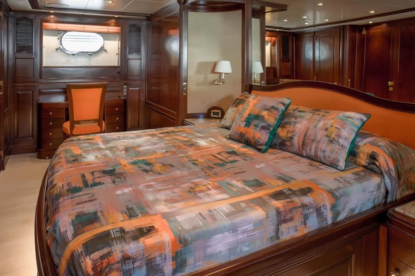 The master stateroom features a luxurious bed with vibrant bedding and elegant wooden furnishings. aboard ANYPA Yacht for Sale