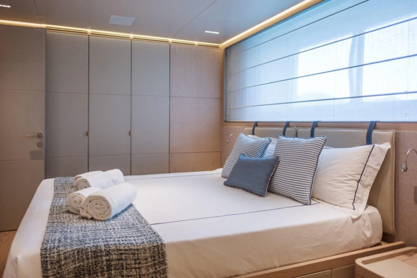 A serene stateroom featuring a comfortable bed with neatly arranged linens and soft lighting. aboard TOLEMAI Yacht for Sale